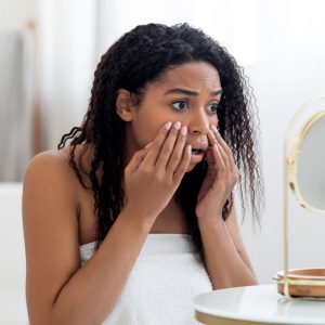 Vrouw met donkere huid die haar haar aanraakt